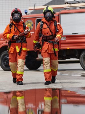 A team of confident and accomplished firefighters strides purposefully in their uniforms, exuding pride and satisfaction after successfully completing a challenging firefighting mission.